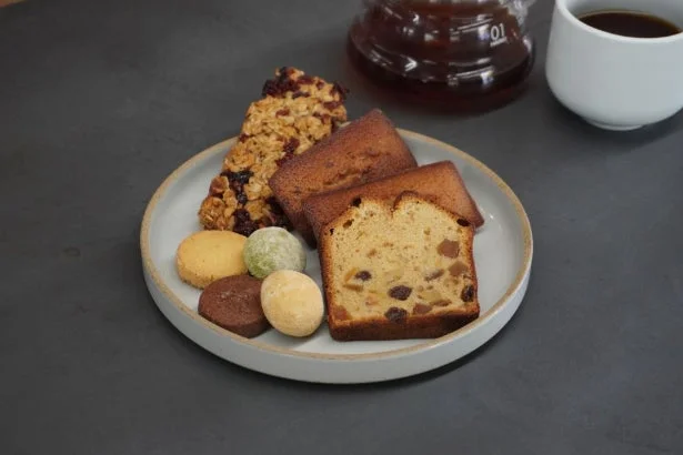 様々な種類の焼き菓子とコーヒーが並べられたカフェテーブル
