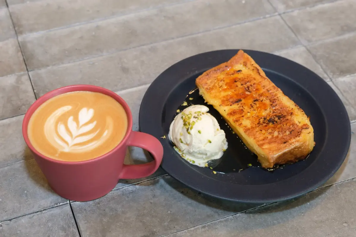 フレンチトーストとアイスクリームが盛り付けられたプレート、そして美しいラテアートが施されたコーヒー