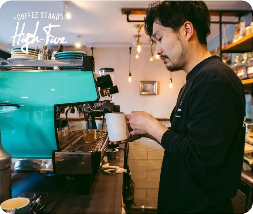 COFFEE STAND High-Fiveでエスプレッソマシンを使うバリスタ