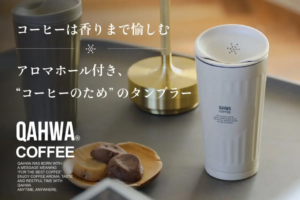 Promotional image for QAHWA Coffee white takeaway cup cookies on a tray with Japanese text about enjoying the aroma