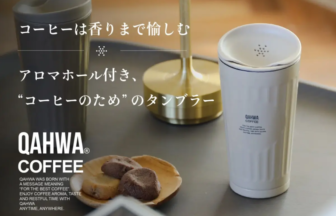 Promotional image for QAHWA Coffee: white takeaway cup, cookies on a tray, with Japanese text about enjoying the aroma.