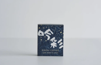 Small navy box of coffee packaging with white Japanese characters placed on a white surface