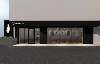Front of Fender Cafe with large glass windows showing tables inside and guitar logo sign above the entrance.