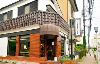 Corner coffee shop with red brick exterior and brown awning Breworld Coffee sign on the street corner storefront