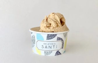 Scooped beige gelato in a patterned cup labeled Gelateria Santi