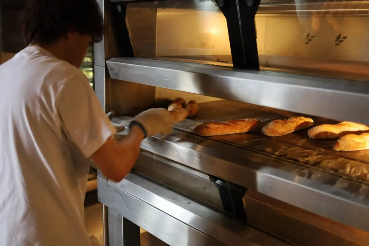 パン職人がオーブンでパンを焼く様子