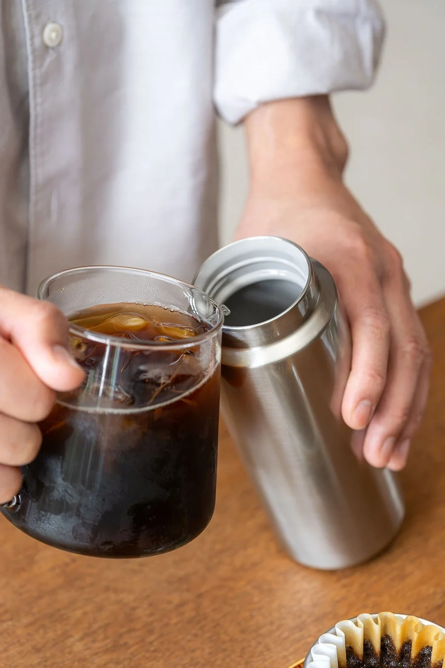 アイスコーヒーとボトルを持つ手