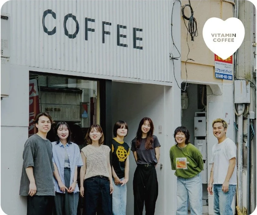 COFFEE VITAMINの店舗前で笑顔の男女グループ