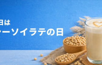 Japanese banner announcing 'June 12 is Healthy Soy Latte Day'; foreground shows a glass of latte with heart foam, bowls and spoons of soybeans, and a milk jug on a blue background.