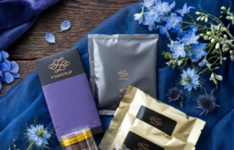 Fathers Day gift set featuring assorted chocolates and elegant wrappers on blue fabric with blue flowers
