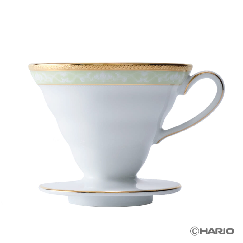 Elegant white porcelain teacup with a gold rim and pale green decorative band placed on a matching saucerstanded base