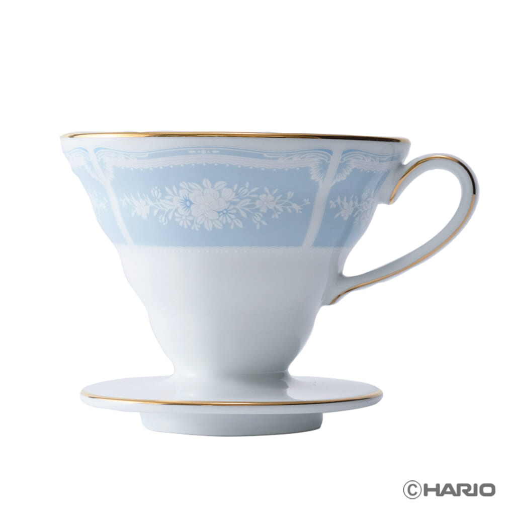 Porcelain teacup with a pale blue upper half white lower half featuring a floral pattern and gold rim and handle on a matching saucer