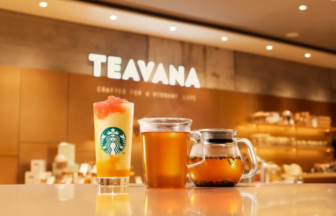 Teavana storefront interior with three beverages on a glossy counter a layered iced drink with Starbucks logo a hot tea and a glass teapot