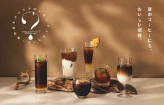 Row of iced coffee drinks arranged on a wooden slab, with a round logo on the left and vertical Japanese text on the right.