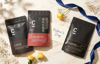 Three black resealable pouches labeled Cocoa, Coolong Tea, and Coffee Premium, arranged beside a Father's Day card, yellow roses, and a blue ribbon.