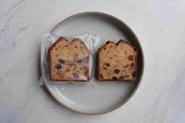 皿の上に置かれた2切れのフルーツパウンドケーキ