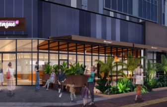 Glass front restaurant named Merengue with outdoor seating and people walking along a plant lined sidewalk storefront