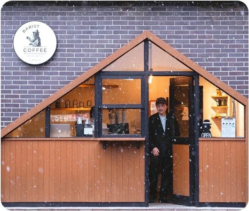 BARIST COFFEEの店舗入口に立つ男性