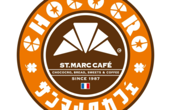 Circular St. Marc Café logo with an orange outer ring featuring star icons and Japanese text; brown center shows a white geometric fan emblem, the name 'ST. MARC CAFÉ', 'SINCE 1987', and a small French flag.