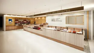 Bright cafebakery counter with a long glass display of cakes and warm wood shelving labeled SAISON DES RÉCOLTES overhead Informative image showing a dessert display area and storefront signage