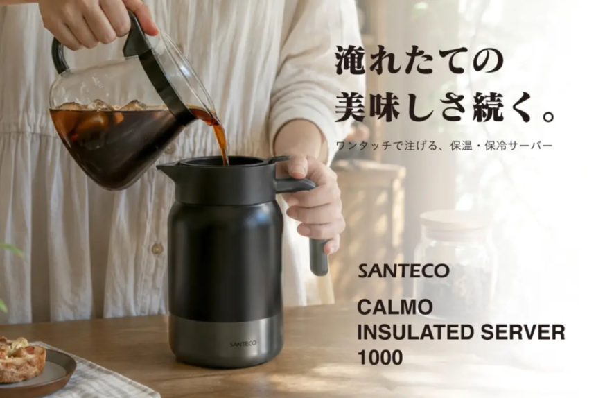 Person pours hot coffee from a glass carafe into a black Santeco Calmo insulated server on a wooden table poster