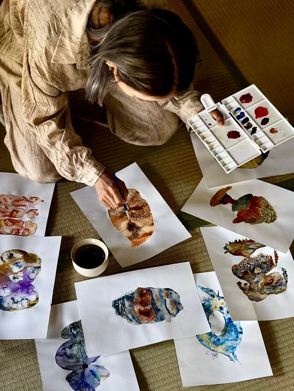 畳の上で女性が水彩画を描く様子
