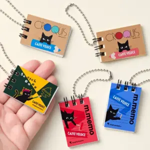 2dd9c90a705ae0ecd4695cad8eafc675 | コーヒーステーション Assorted miniature notebooks on silver ball chains each with a black cat and CAFFE VELOCE branding on colorful covers