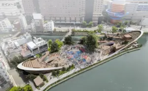 Aerial view of a boat shaped urban park on a river with terraces trees and a busy central plaza area filled with people and colorful surfaces