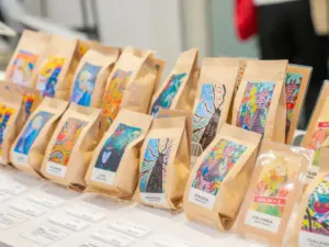 Brown paper coffee bags with vibrant labels lined up on a display table at a market stall origins printed on labels like Indonesia and Ethiopia