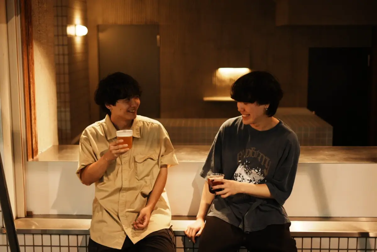 談笑する男性二人、夜のカフェバーの雰囲気