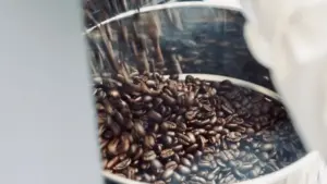 Close up of dark roasted coffee beans inside a metal roasting drum