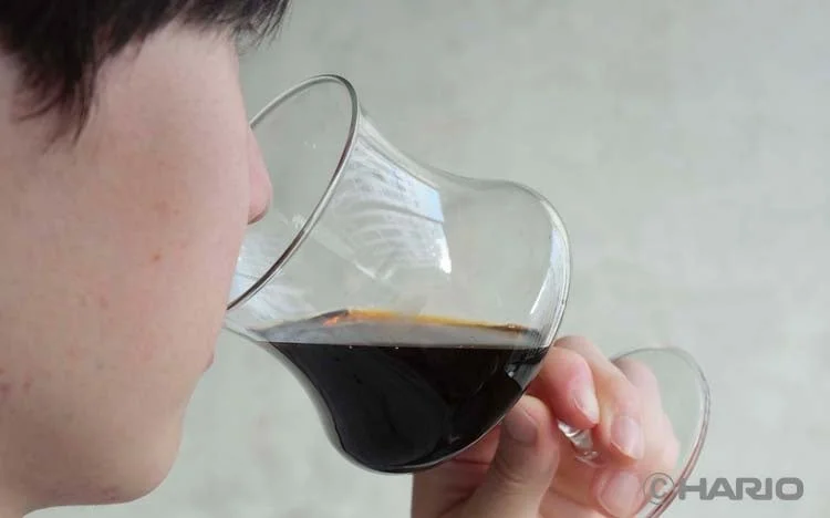 グラスでコーヒーを飲む人