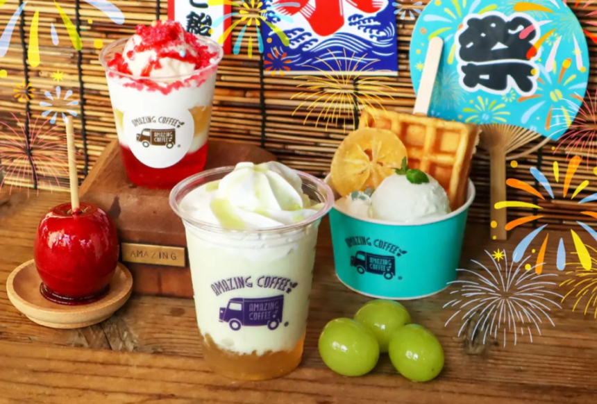 Bright dessert spread two milk based drinks in cups with whipped toppings fruit topping and waffles set on a wooden table with colorful festival banners and fireworks illustrations in the background plus green grapes nearby