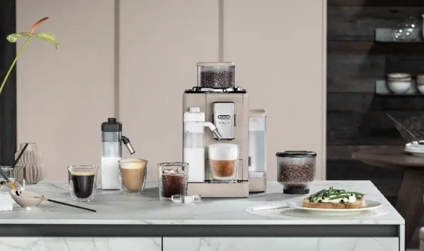 Espresso machine on a kitchen counter with several coffee drinks a grinder and a plate of toast on the right side
