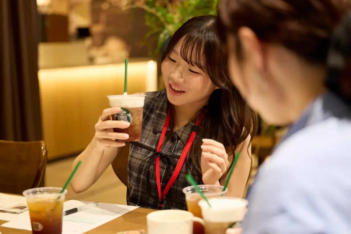 スターバックスのドリンクを持つ女性