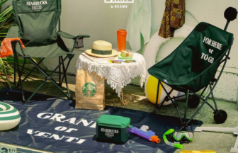 Poolside Starbucks Stand by BEAMS setup with two camping chairs, a lace table, bag, cooler, goggles, and 'STARBUCKS STAND' logo on the wall.