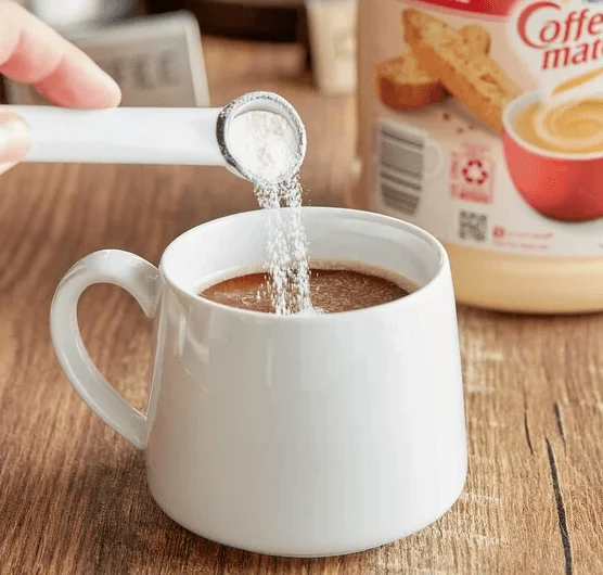 コーヒーにクリーマーパウダーを注ぐ様子