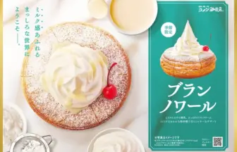 Cake with whipped cream and a cherry on a dusted round base next to a teal promotional panel for Blanc Noire pastry seasonal