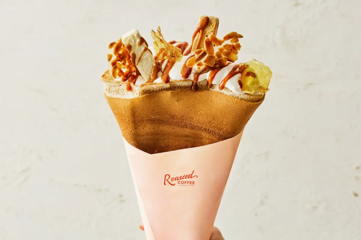 ホイップクリーム、キャラメルソース、アーモンド、バナナなどがトッピングされた美味しそうなクレープ