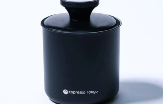 Black cylindrical coffee canister with a white shaker lid Espresso Tokyo logo visible on the front