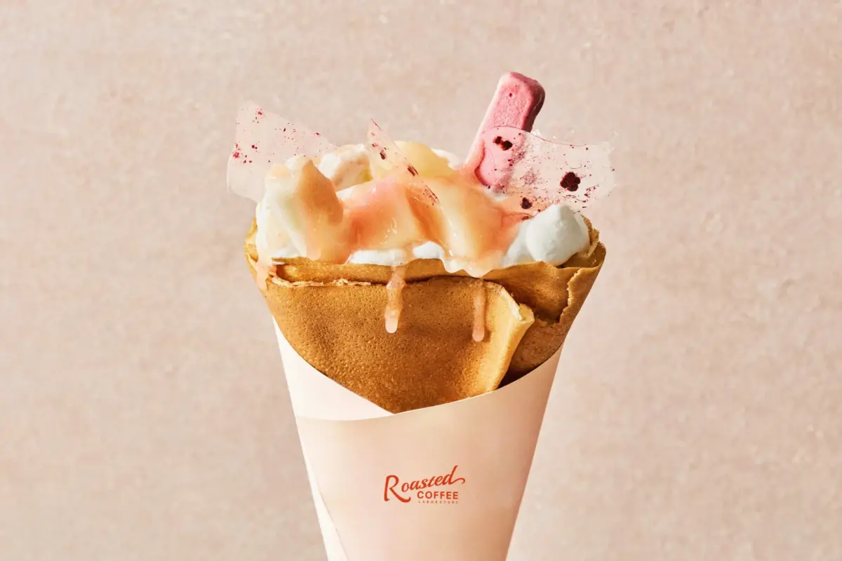 ホイップクリームと桃のソース、フルーツで飾られた美味しそうなクレープ