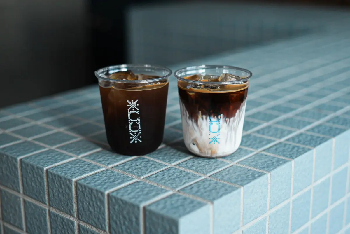 水色のタイルカウンターに置かれたアイスコーヒーとカフェラテ