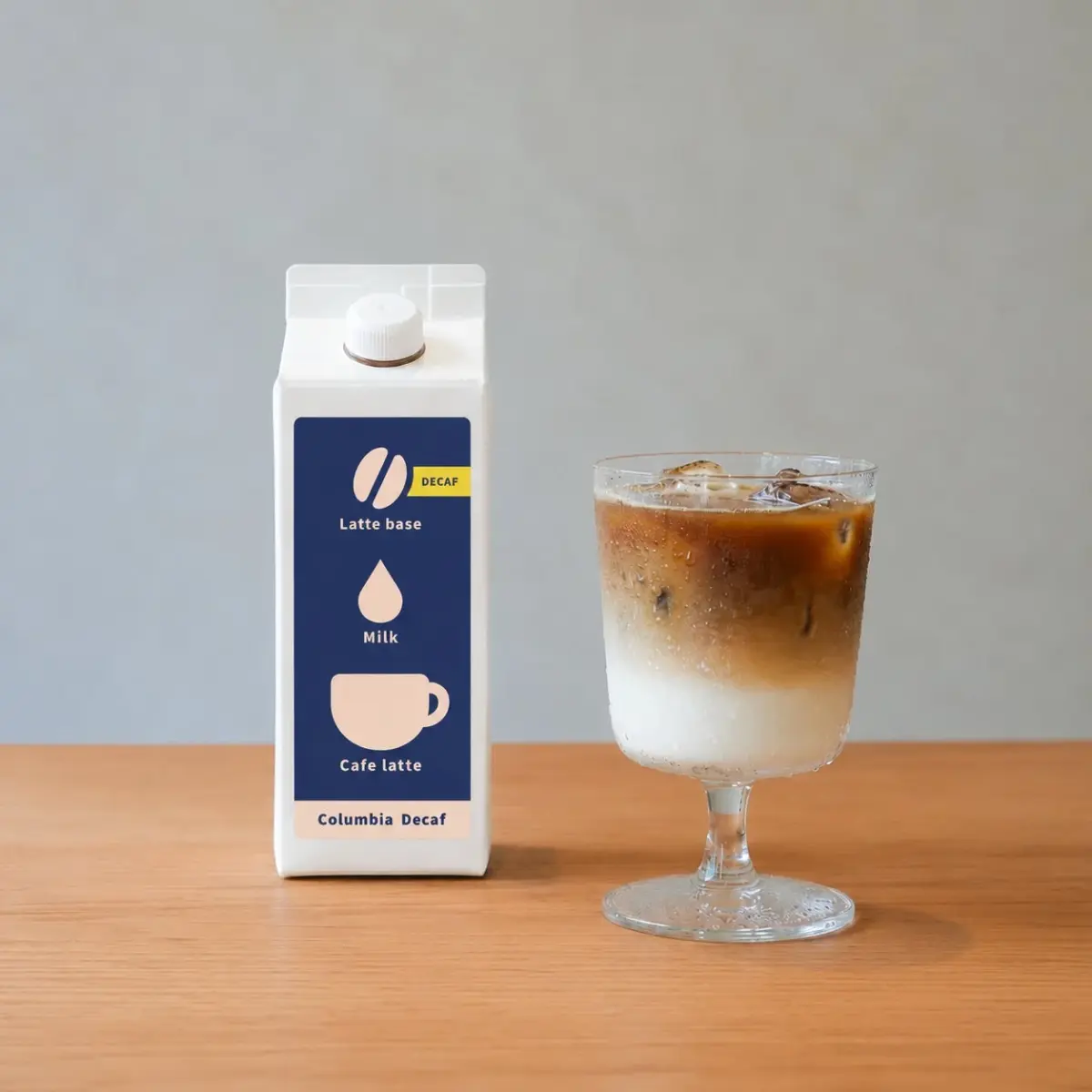 デカフェカフェラテベースの白いパックとアイスカフェラテのグラス