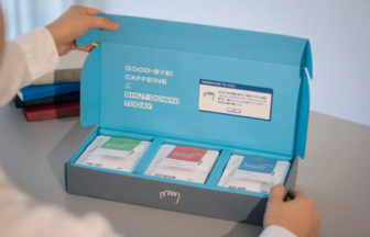 Bright blue box opened to reveal three coffee sachets labeled Fine Light, Rich Medium, and Deep Dark inside a home setting