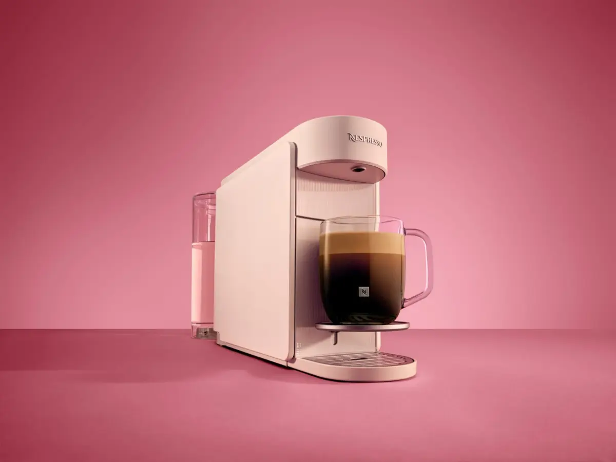 ピンクの背景にネスプレッソコーヒーメーカーとコーヒー