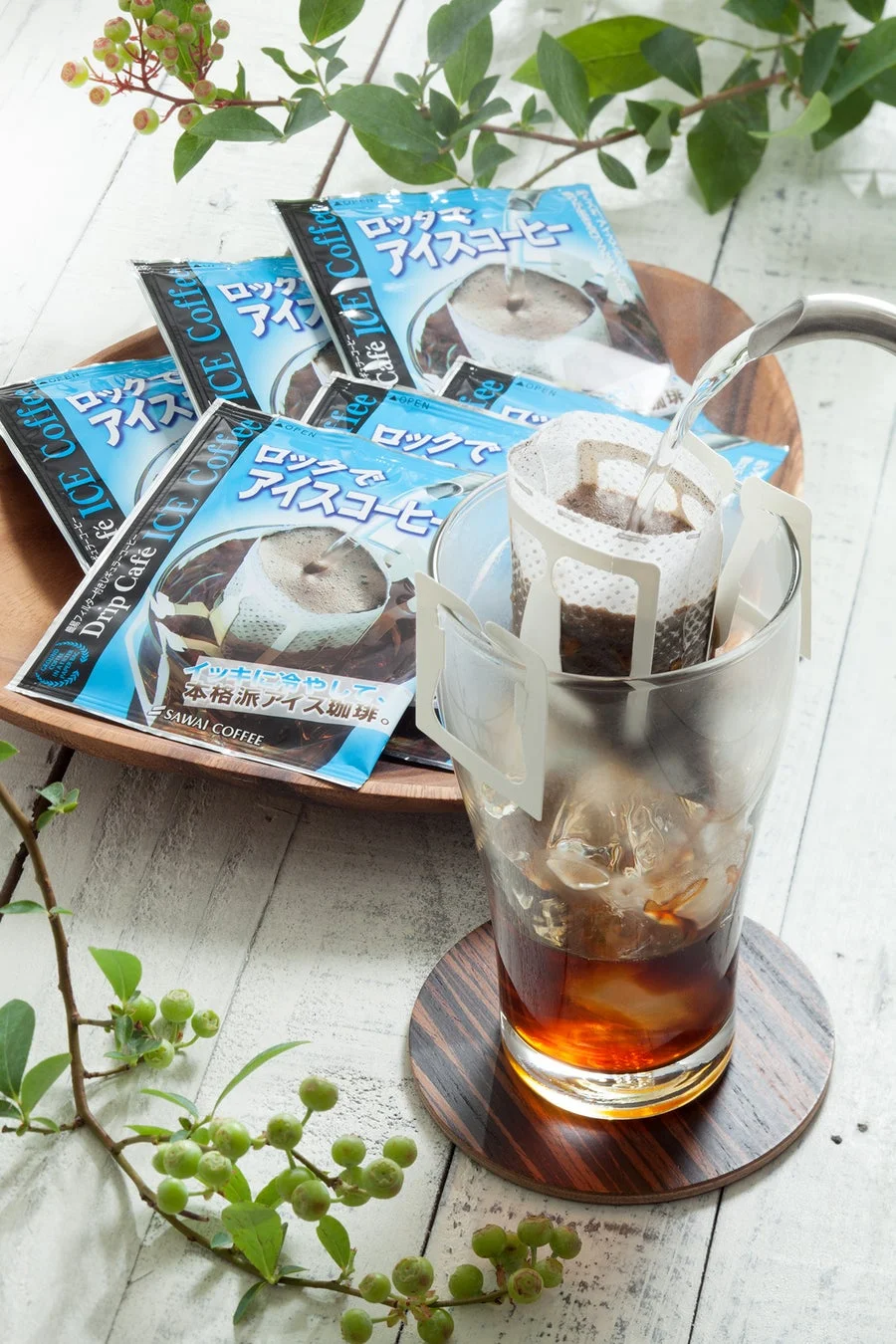 「ロックでアイスコーヒー」のドリップバッグを使って、氷入りのグラスに直接アイスコーヒーを淹れている様子を捉えた画像です。