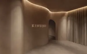 Curved beige interior hallway with an arched doorway and the word KINUO lit on the wall warm ambient lighting