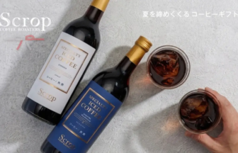 Overhead shot of two bottled iced coffee beverages with gold and blue labels beside two glasses filled with ice, on a textured surface; Scrop branding visible.