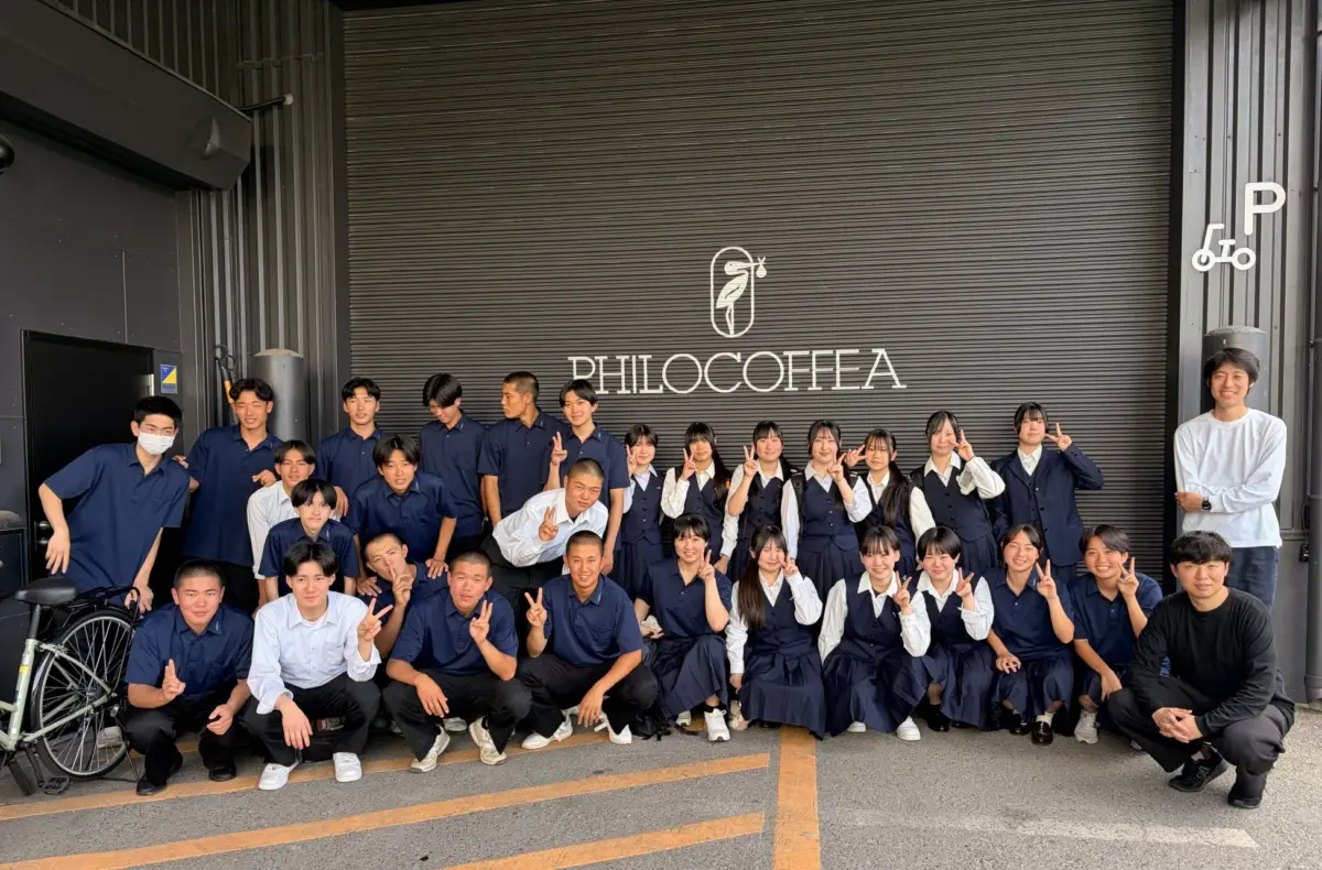PHILOCOFFEA店舗前で集合写真を撮る生徒たち