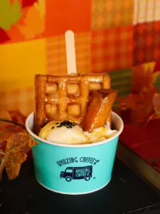3e70ca4b0b9656cc0661c0b0f82b239b | コーヒーステーション Dessert cup with a waffle banana ice cream and caramel in a turquoise Amazing Coffee cup against an autumn themed background